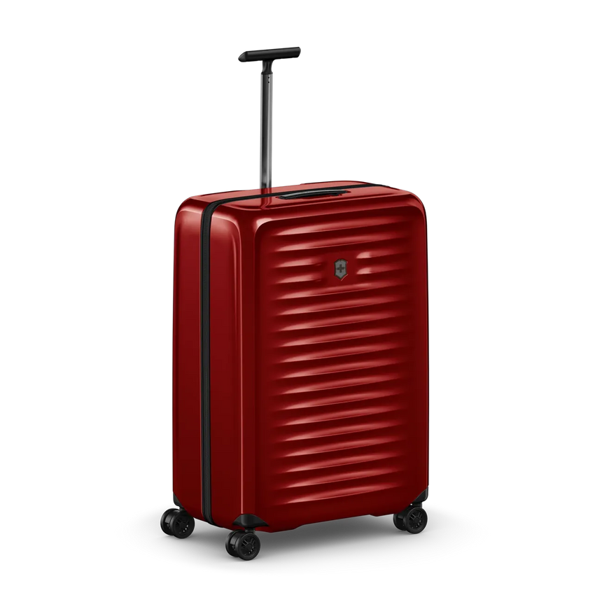Red hardshell rolling suitcase with horizontal ridges and a retractable handle.