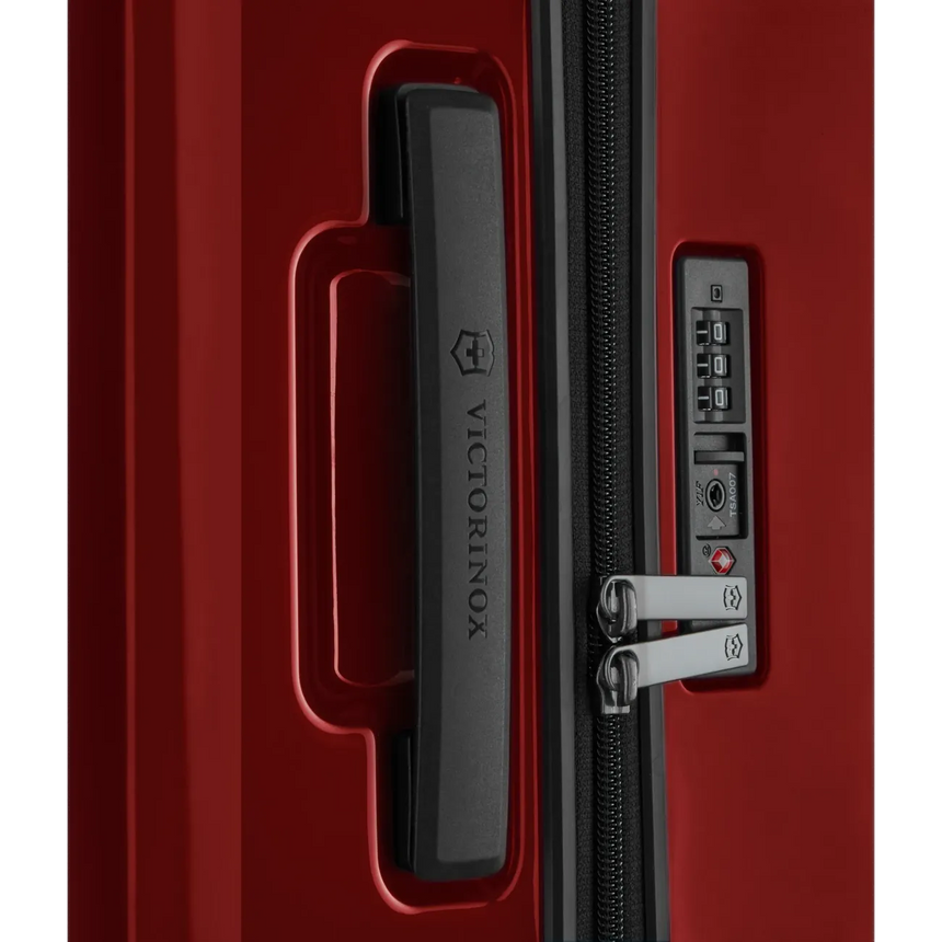 Red hardshell suitcase with a combination lock and zipper.