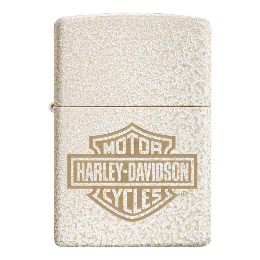 Zippo lighter with a Harley-Davidson logo engraved on a textured cream-colored surface.