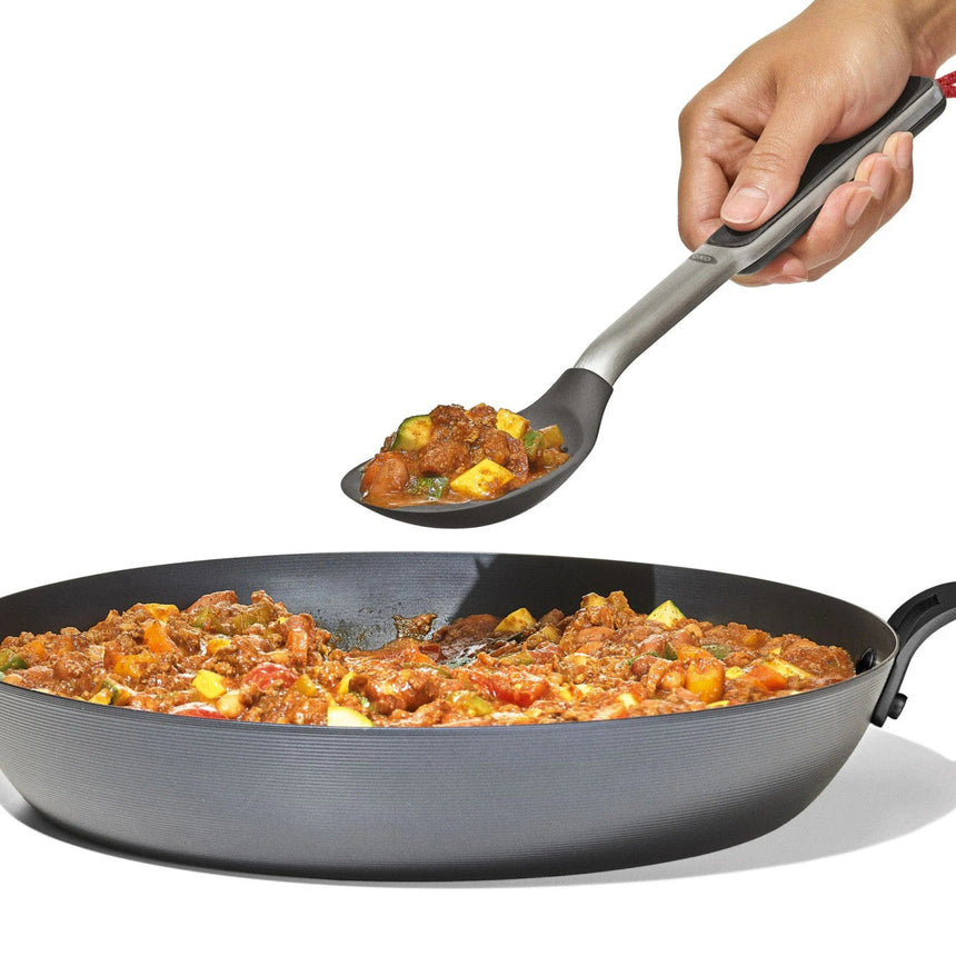 Frying pan containing a colorful meat and vegetable stew or curry dish.