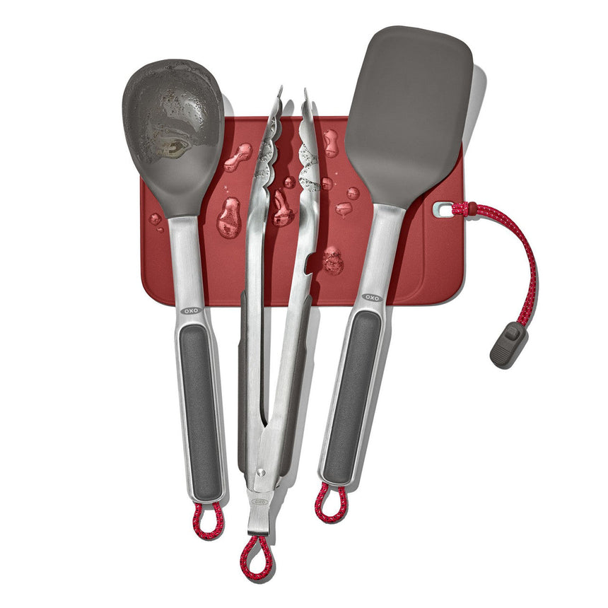 Set of kitchen utensils including spatulas and tongs with a red holder.