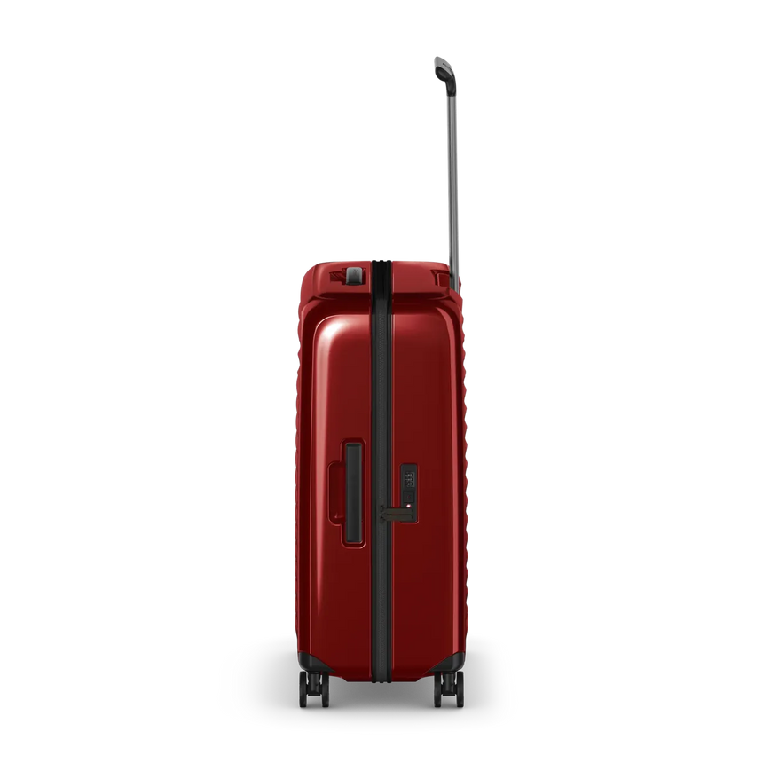 Red hardshell rolling suitcase with an extendable handle and wheels.