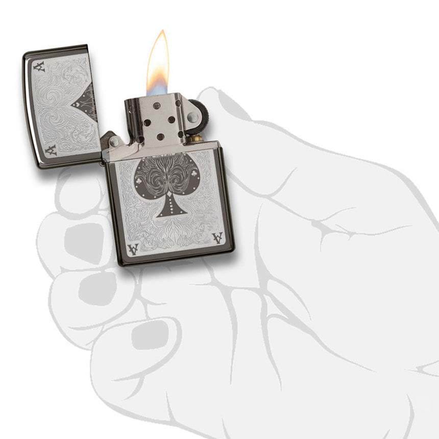 Lit metal lighter with an ace of spades design on its surface.