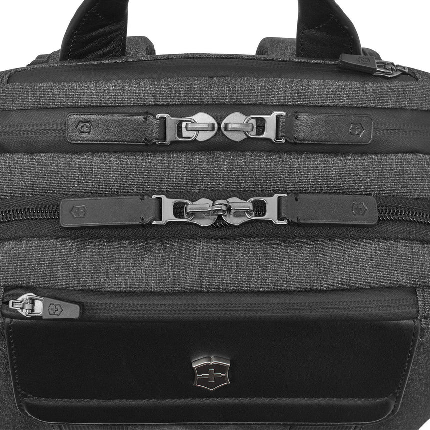 Backpack with multiple zippered compartments and buckle closures.
