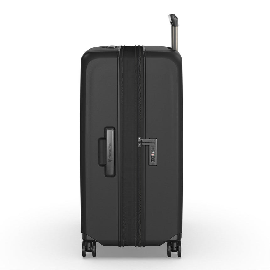 Black hardshell rolling suitcase with telescoping handle and wheels.
