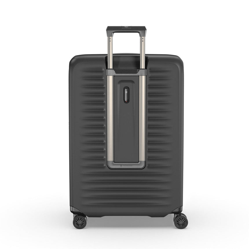 Hard-shell rolling suitcase with horizontal ridges and an extendable handle.
