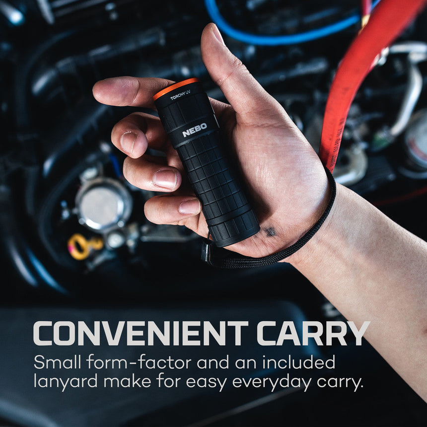 Handheld flashlight with a lanyard attached, held in a person’s hand.
