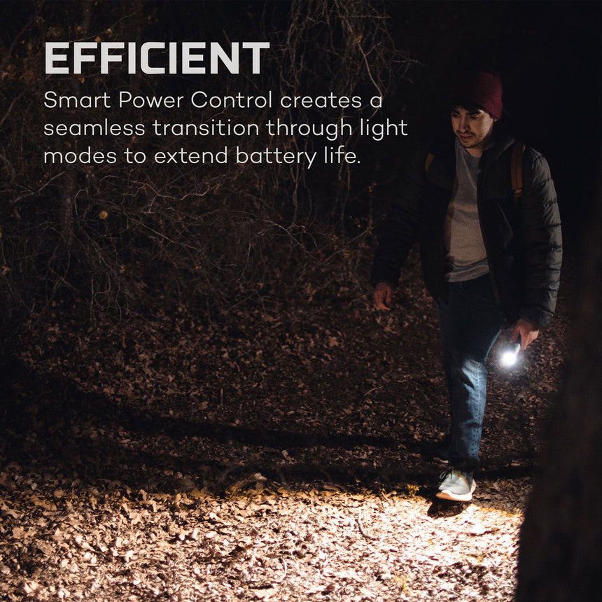 Person walking at night using a handheld flashlight or torch.