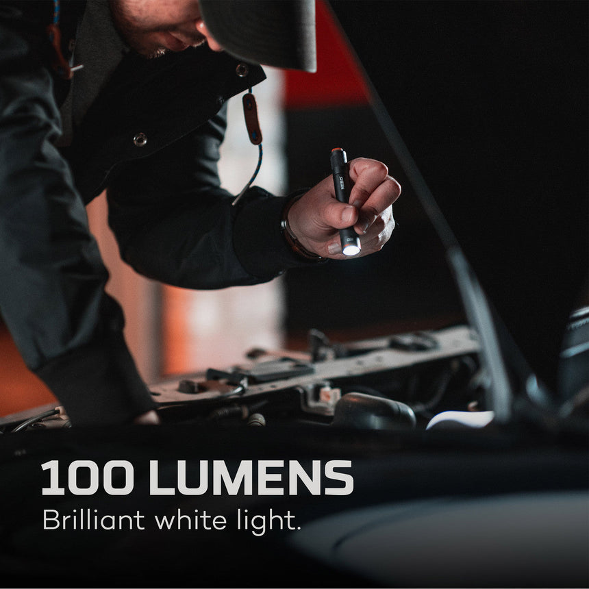 Handheld flashlight being used to illuminate a car engine compartment.