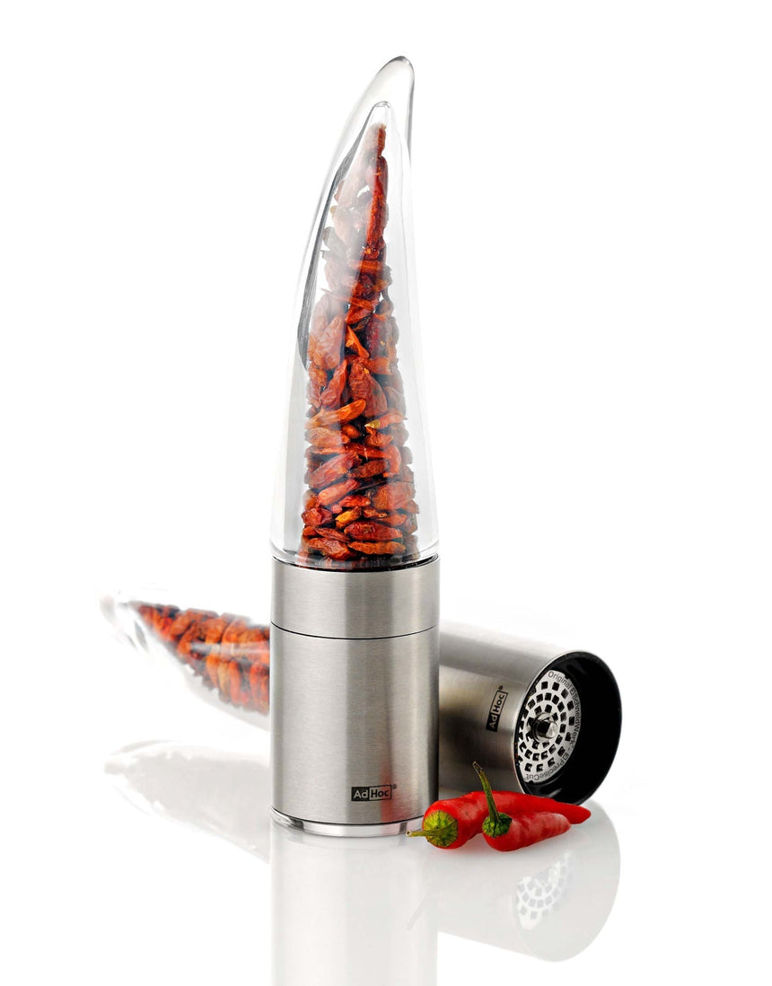 Stainless steel spice grinder filled with red chili peppers.