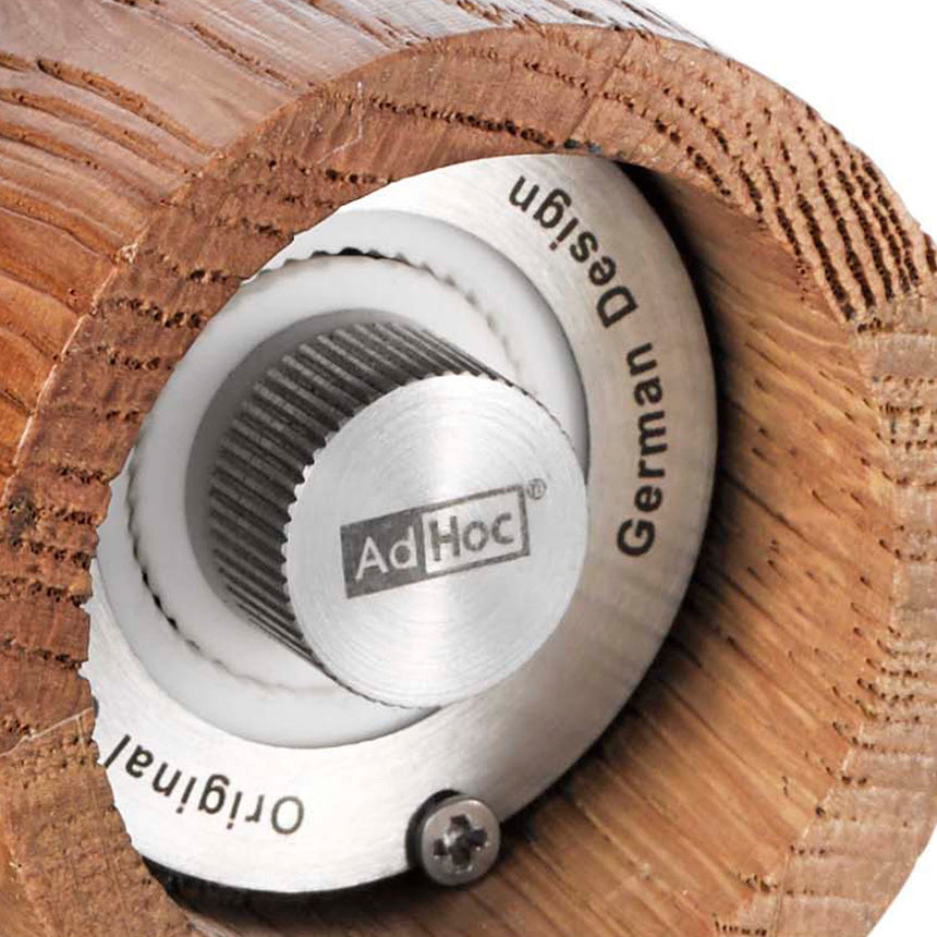 Circular white pepper mill or grinder with ’AdHoc’ branding.