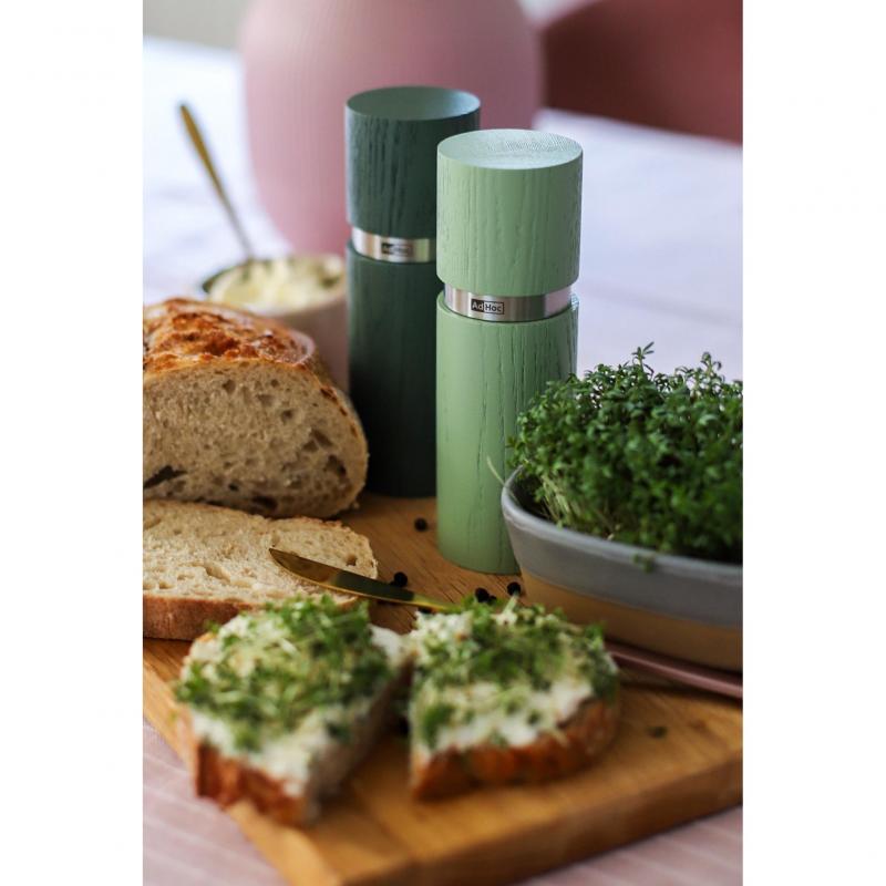 Sliced bread with herb spread on a wooden cutting board.