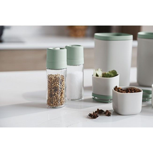 Set of kitchen containers and spice grinders with mint green lids.