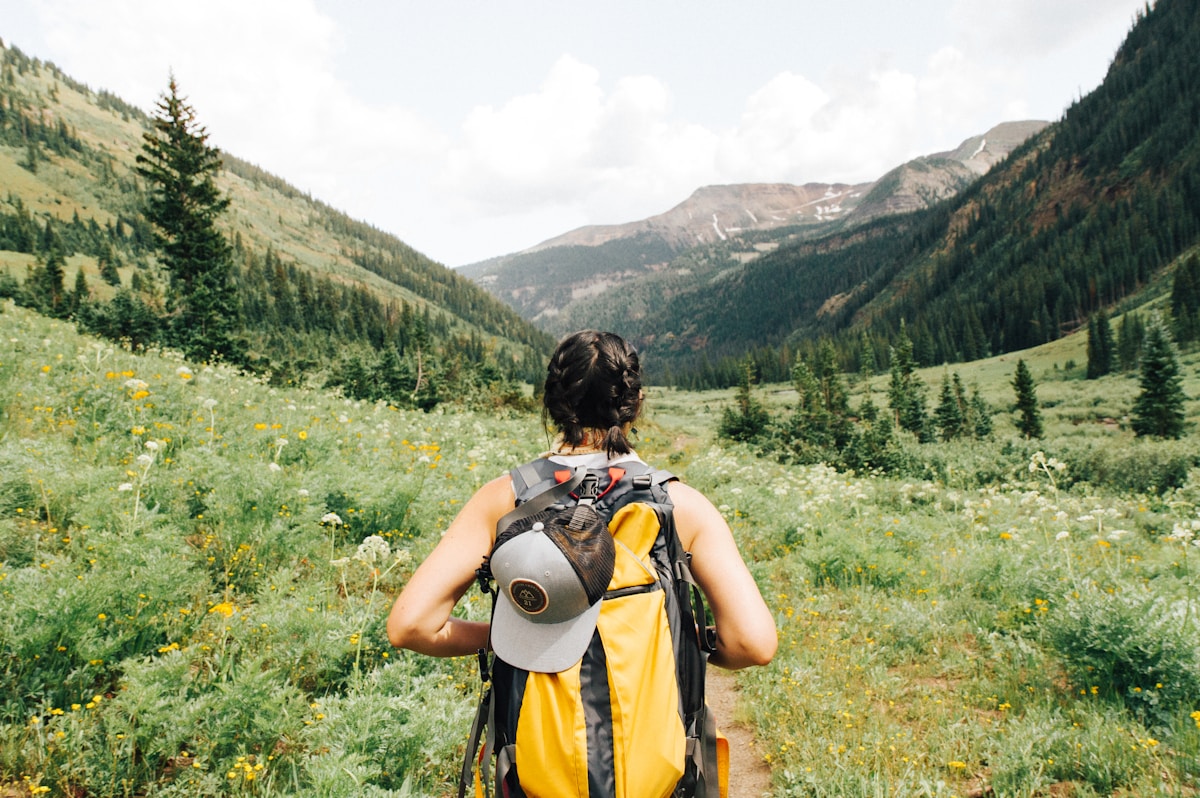 Woman hiking with a travel backpack in the mountains
