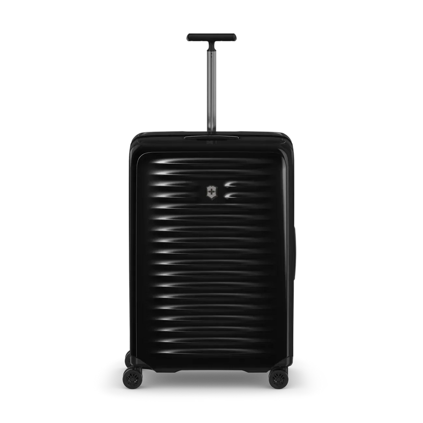 Black hard-shell rolling suitcase with horizontal ridges and an extendable handle.