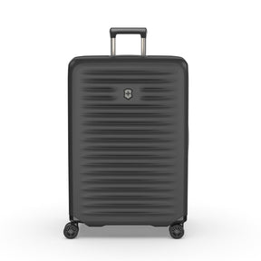 Black hardshell rolling suitcase with horizontal ridges and a retractable handle.