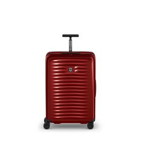Red hardshell rolling suitcase with horizontal ridges and a retractable handle.