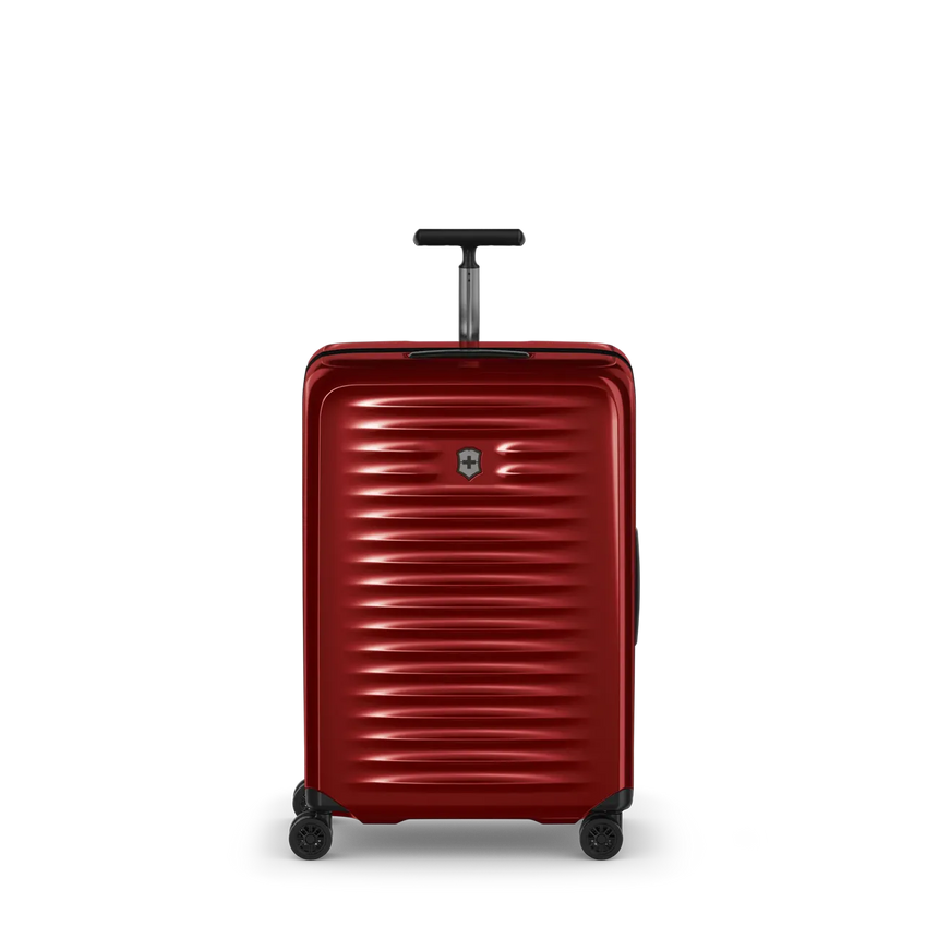 Red hardshell rolling suitcase with horizontal ridges and a retractable handle.