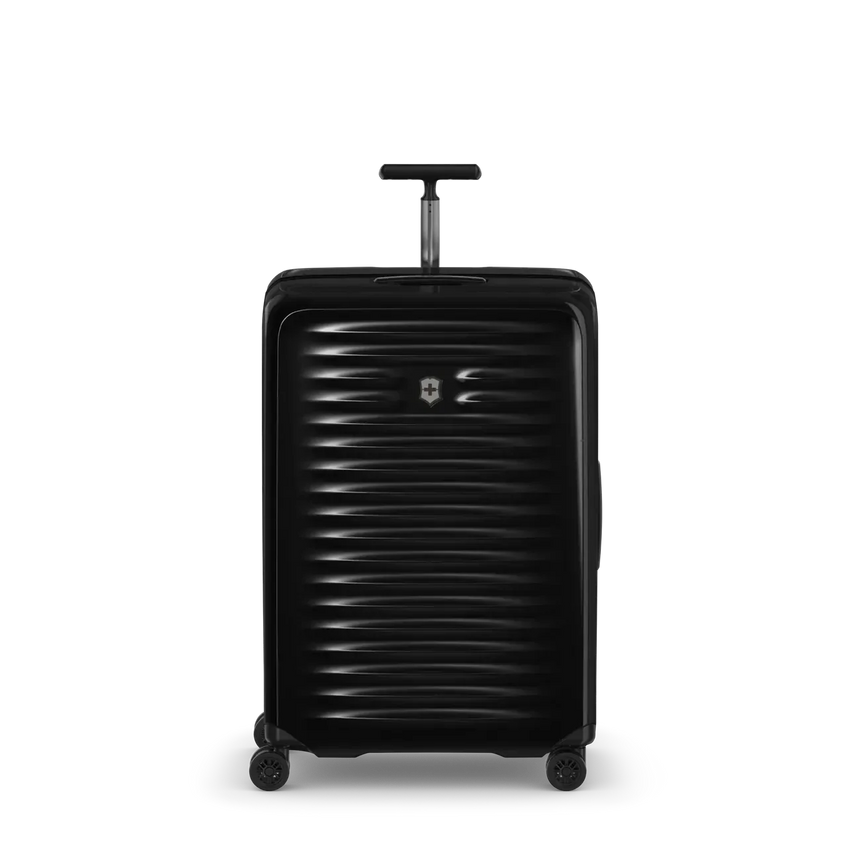 Black hardshell rolling suitcase with horizontal ribbed texture and extendable handle.