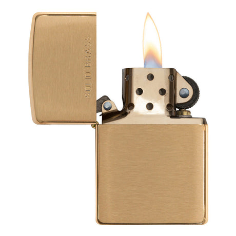 Gold-colored metal lighter with an open lid and lit flame.