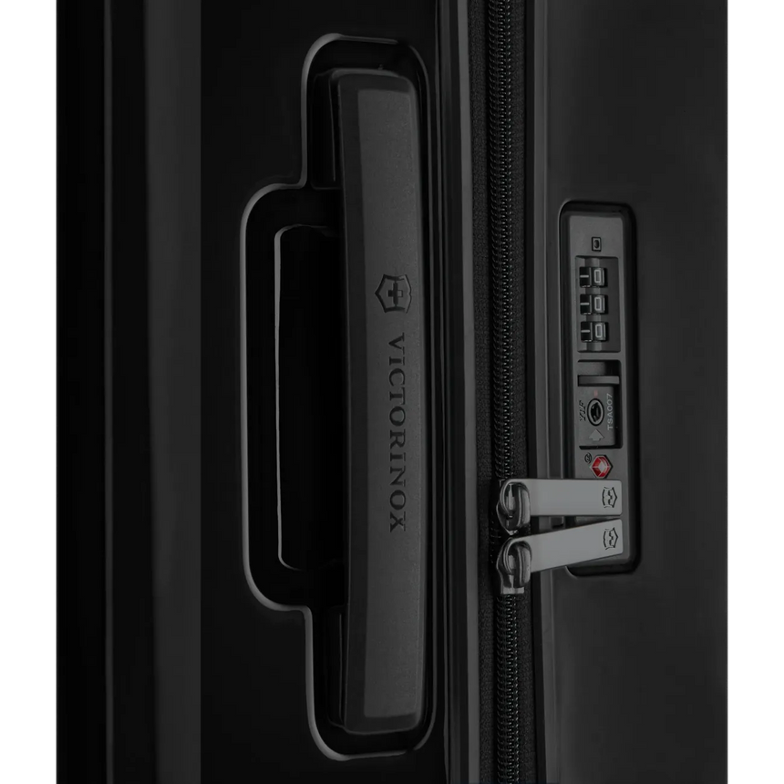 Luggage handle and combination lock on a black suitcase.