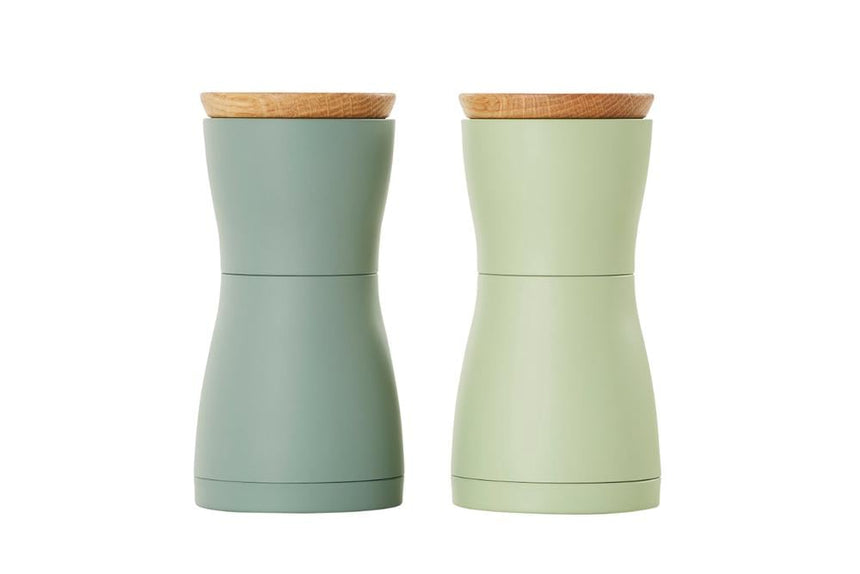 Two pastel-colored salt and pepper grinders with wooden lids.