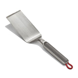 Stainless steel spatula with a black handle and red hanging loop.