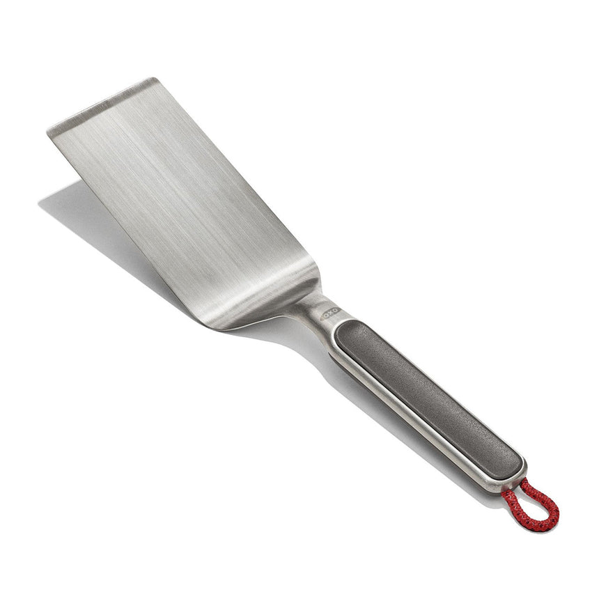 Stainless steel spatula with a black handle and red hanging loop.
