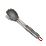Metal cooking spoon with a gray handle and red hanging loop.