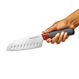 Chef’s knife with a wide, dimpled blade and a red and gray ergonomic handle.