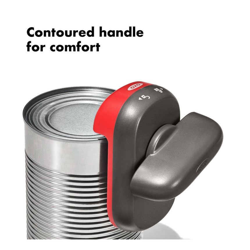 Electric can opener with a contoured handle attached to a metal can.