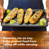 Four grilled corn cobs topped with seasonings and served with lime wedges on a metal tray.