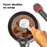 Frying pan containing cooked ground meat with a white utensil scooping some out.