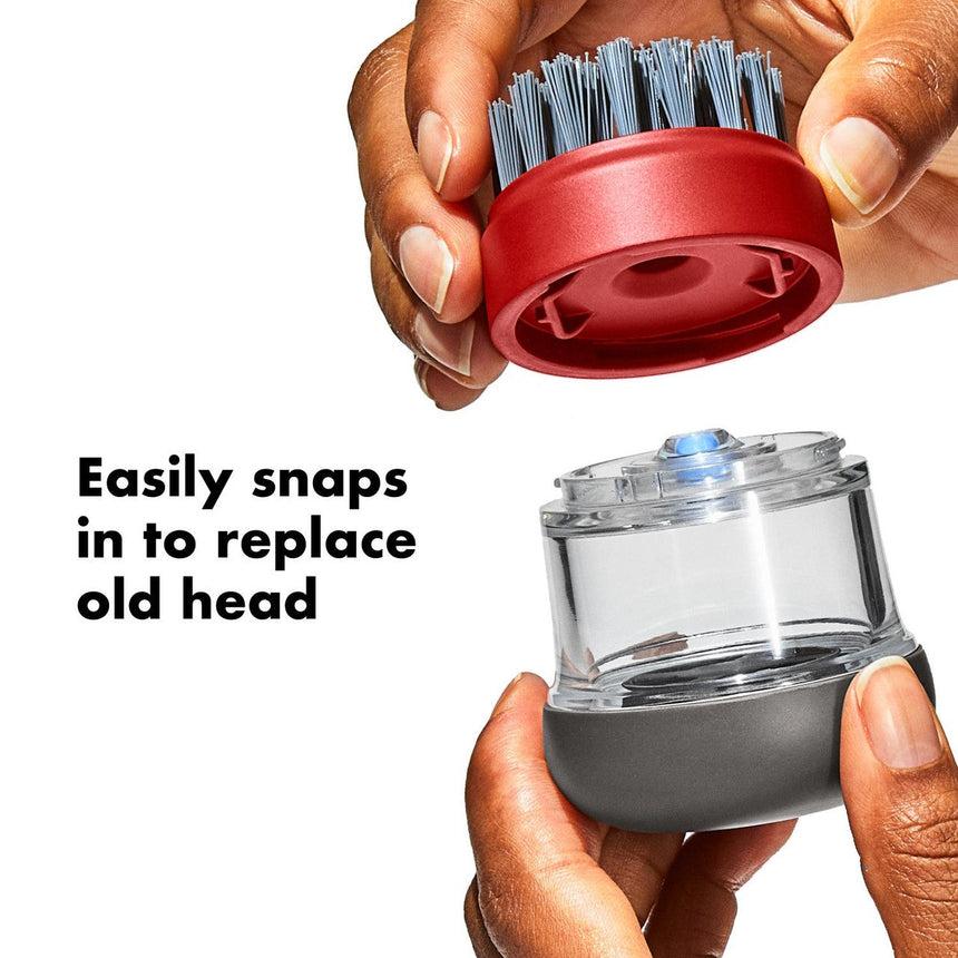 Replaceable brush head for a cleaning device with a clear container and red top.