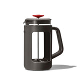 French press coffee maker with a dark gray body and red lid.