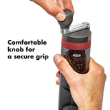 Manual coffee grinder with a transparent chamber containing coffee beans and a comfortable knob on top.