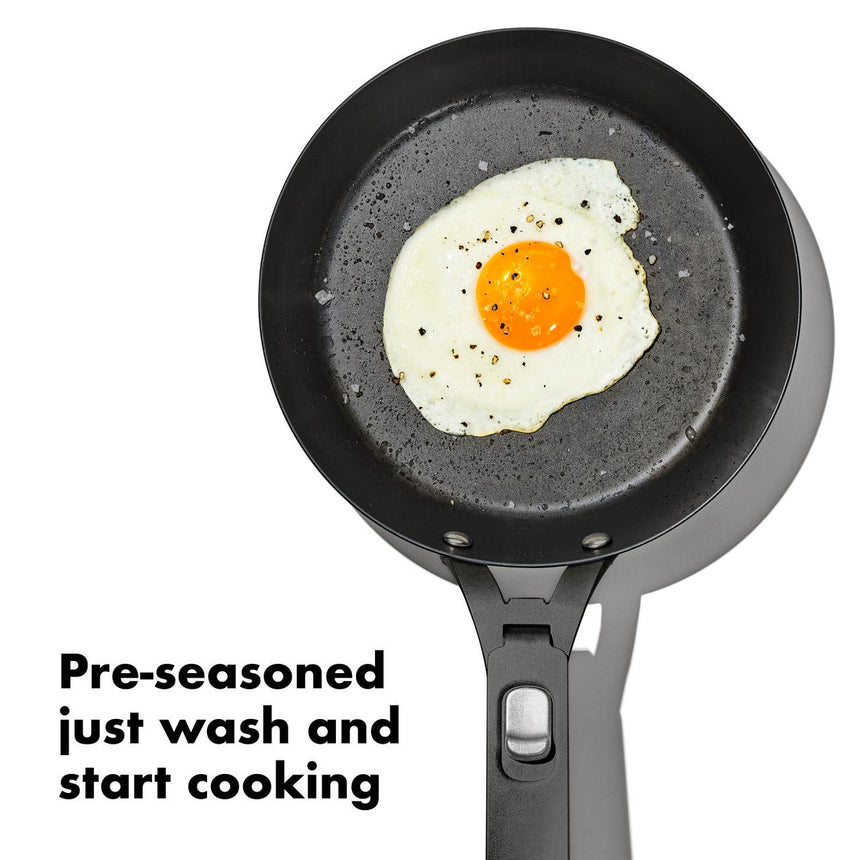 Black non-stick frying pan with a fried egg in the center.