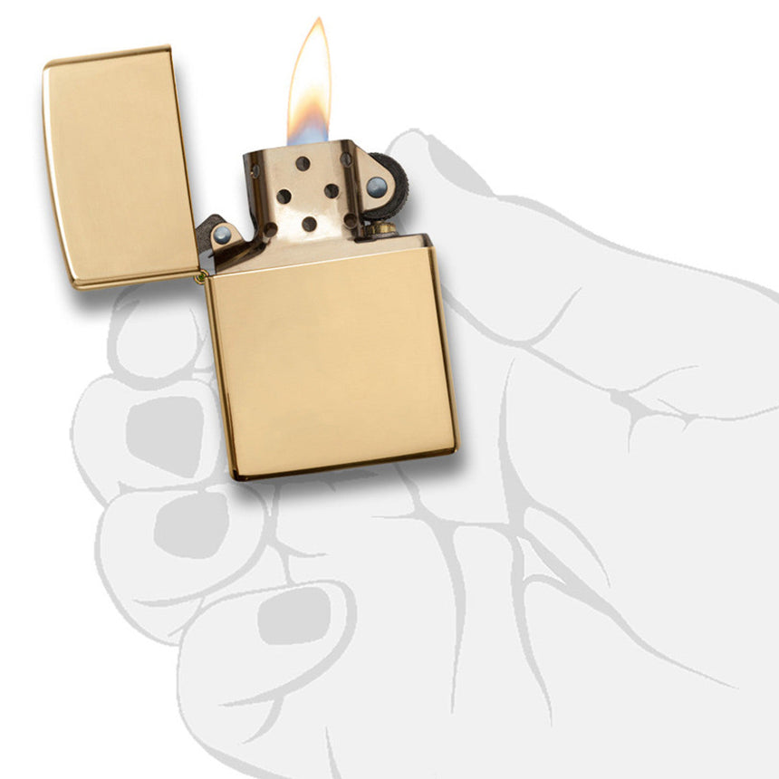 Gold-colored metal lighter with an open lid and visible flame.