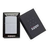 Zippo lighter in its packaging, consisting of a metal lighter and a black box with the Zippo logo.
