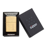 Gold-colored Zippo lighter with engraved floral design in its presentation box.