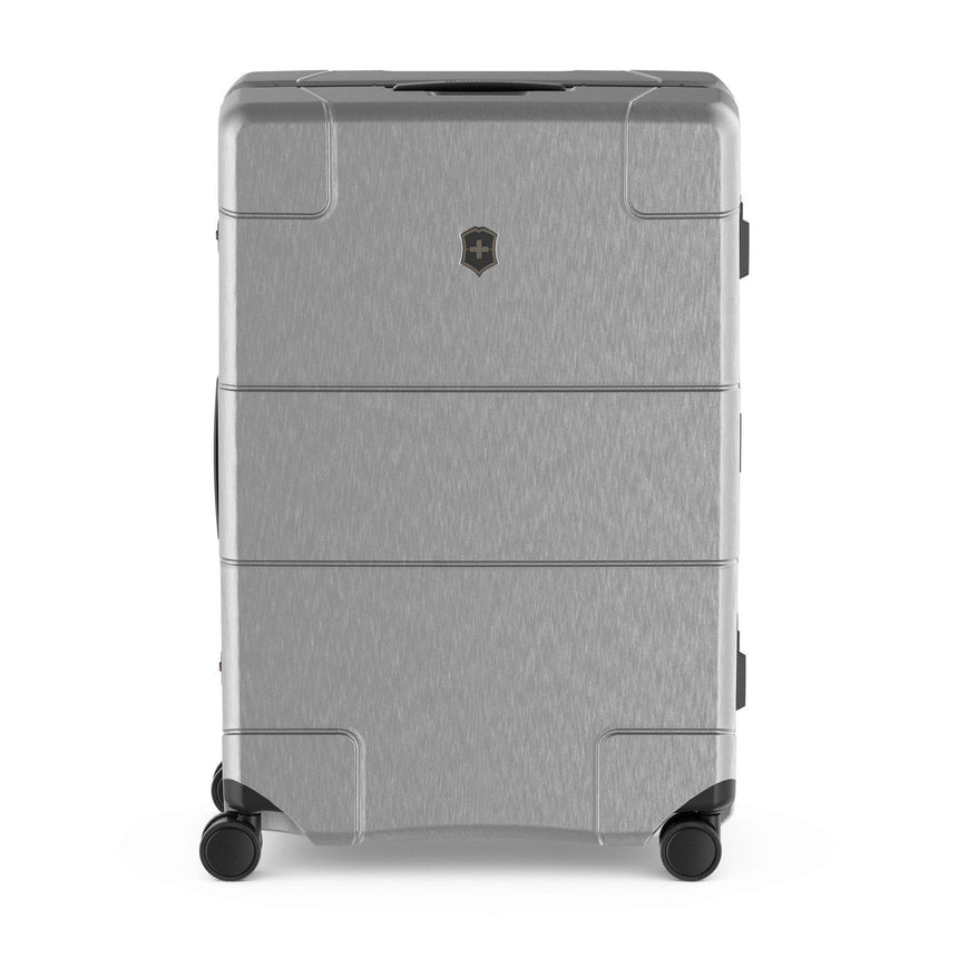 Silver hardshell rolling suitcase with horizontal ridges and a logo emblem.