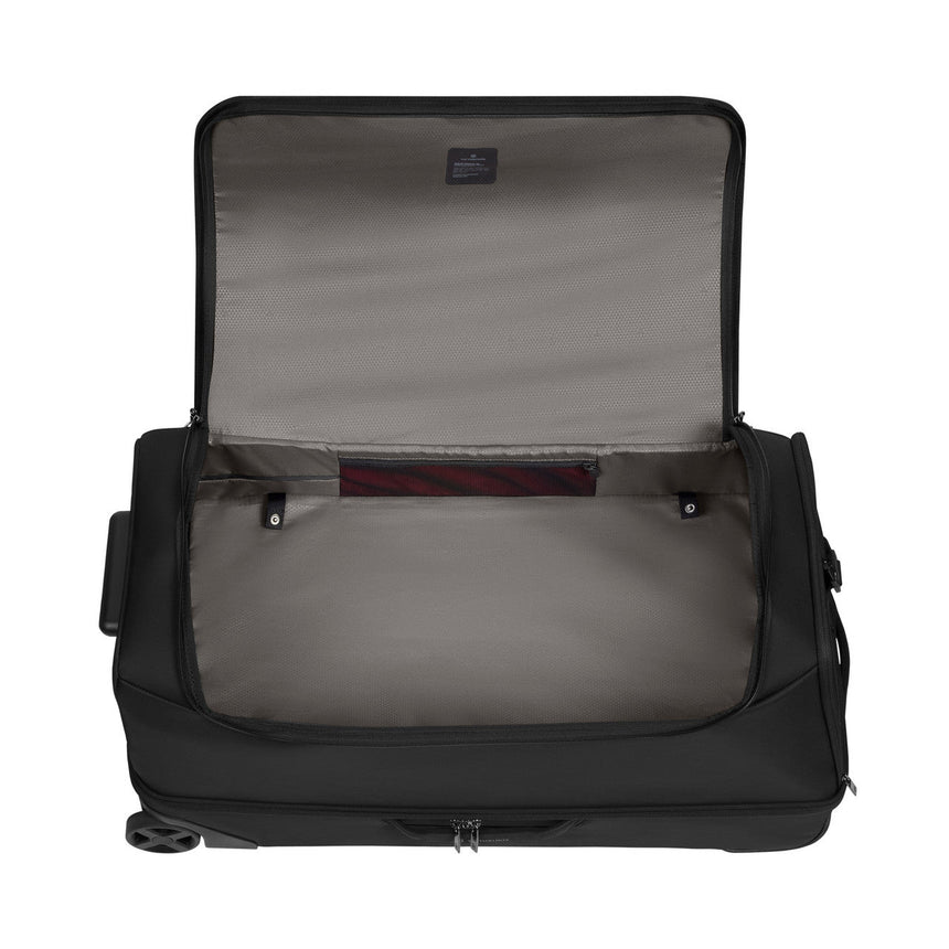 Open black wheeled suitcase or travel bag with a light-colored interior lining.