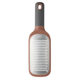 Kitchen grater with a rose gold-colored handle and gray grating surface.