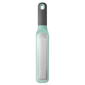 Mint green and gray kitchen grater with a long handle.