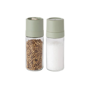 Salt and pepper shakers with pale green tops and clear glass bodies.