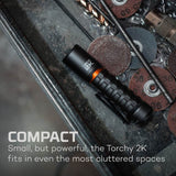 Black cylindrical flashlight with textured grip and orange accents.