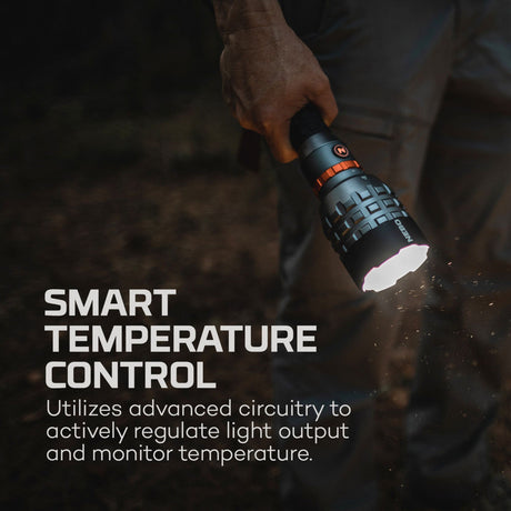 Handheld flashlight with smart temperature control feature being illuminated in a dark setting.