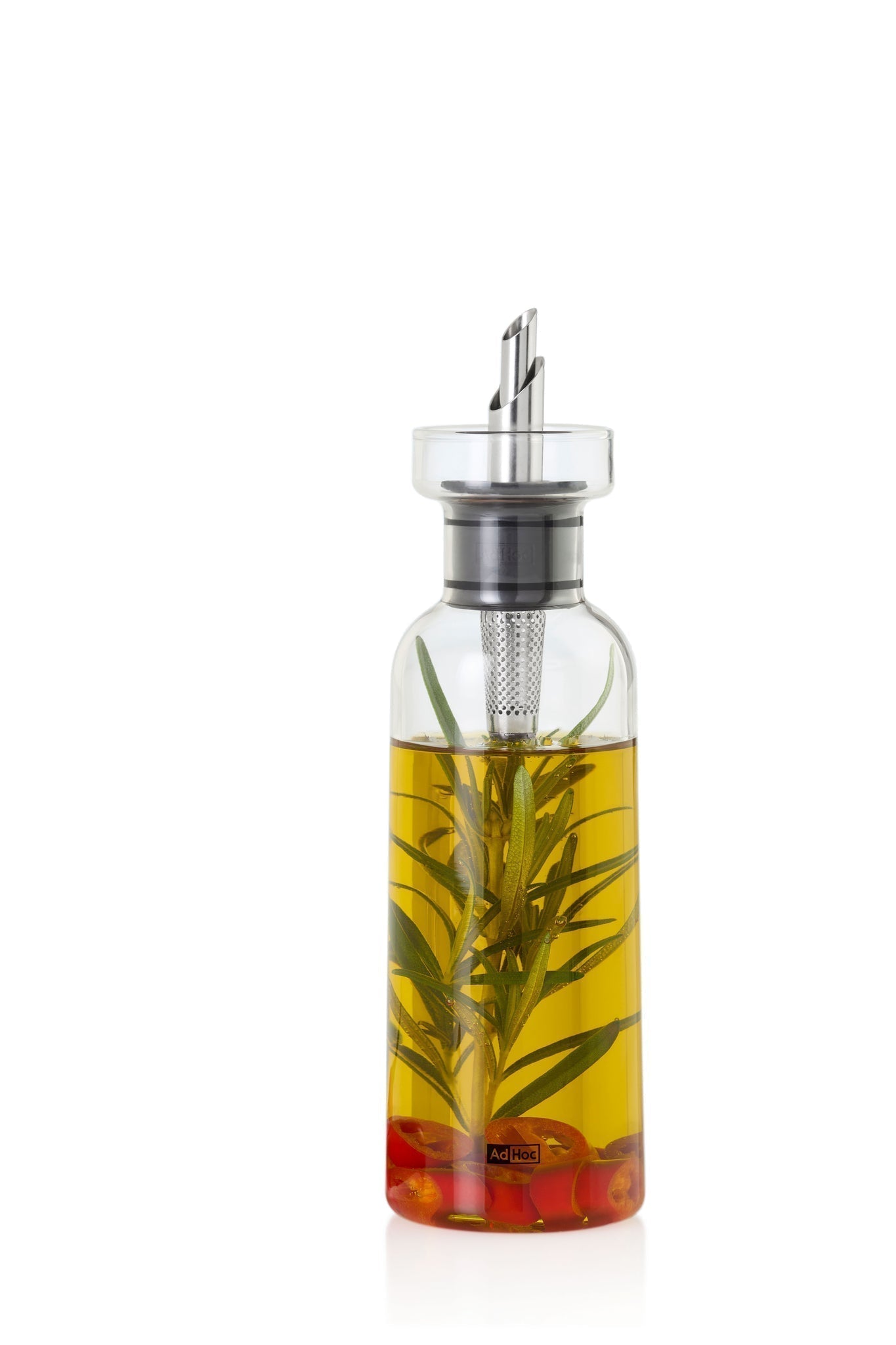 Glass bottle containing yellow oil with herbs and red peppers infused inside.