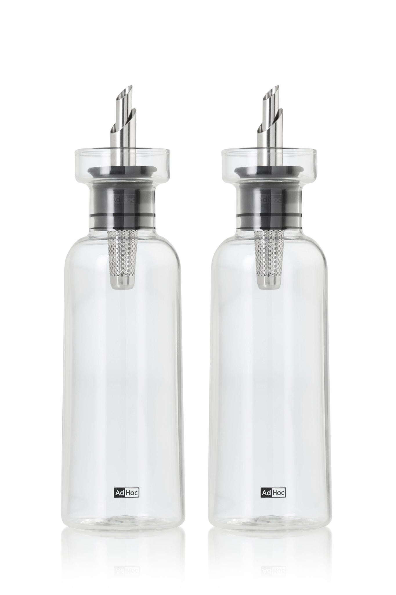 Two clear glass oil or vinegar dispensers with metal pouring spouts.