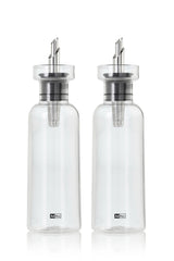 Two clear glass oil or vinegar dispensers with metal pouring spouts.